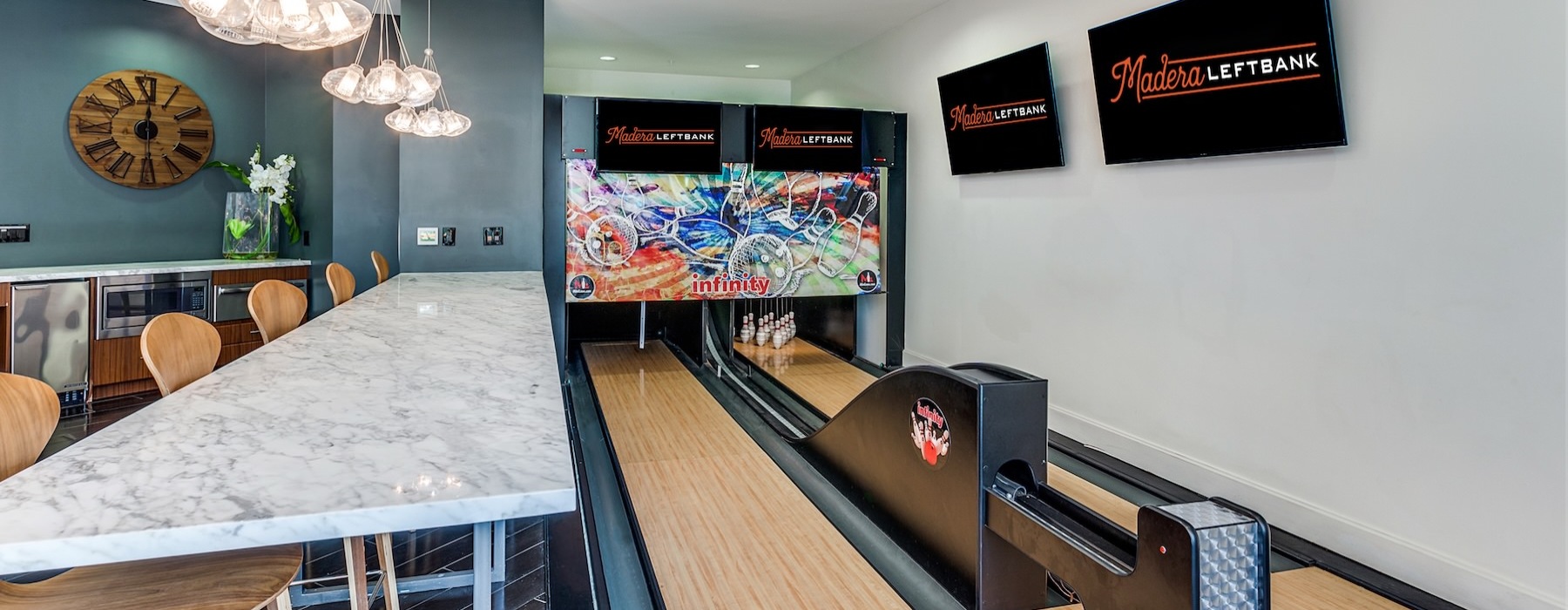 a room with a bowling alley and a bench with chairs