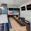 a room with a bowling alley and a bench with chairs